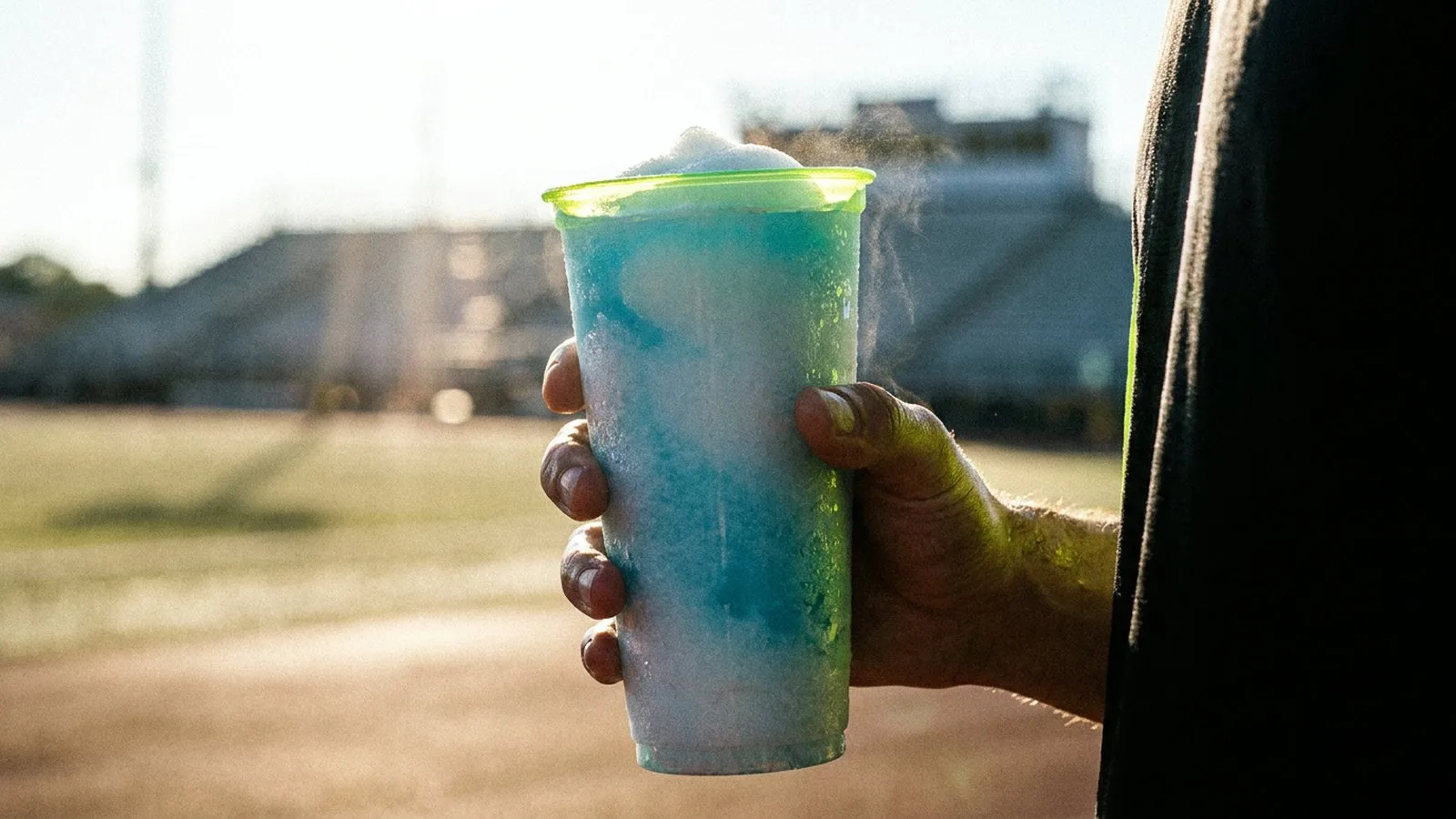 Runner holding a cup of ice slurry for precooling before a hot race